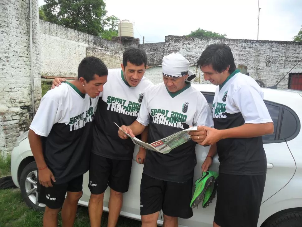 CONCENTRADOS. Sergio Romero lee LG Deportiva rodeado por varios de sus compañeros del plantel “Cuervo”.  	foto de jorge diaz