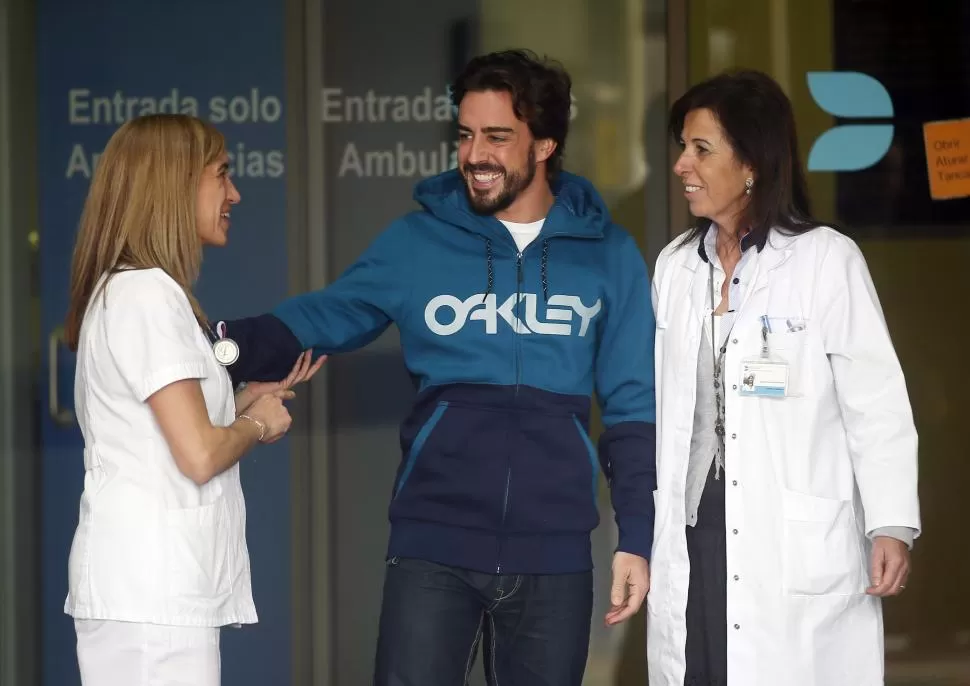 BIEN CUIDADO. Alonso agradece a sus doctoras en la salida del hospital de Cataluña. El asturiano se mostró de buen humor. reuters