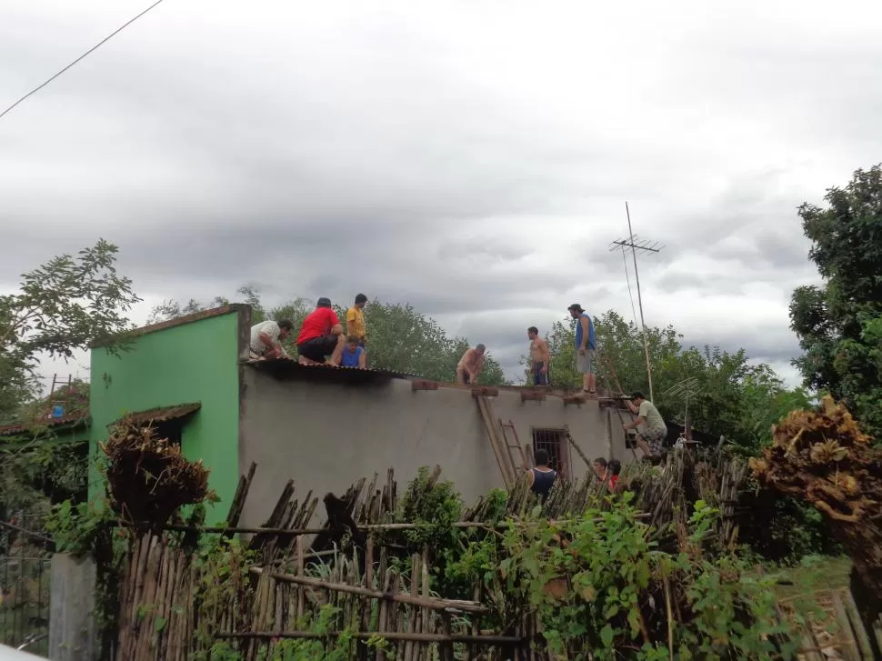 EN ALPACHIRI. Albañiles y vecinos trabajan en el techo de una de las viviendas afectadas por el fuerte viento. 