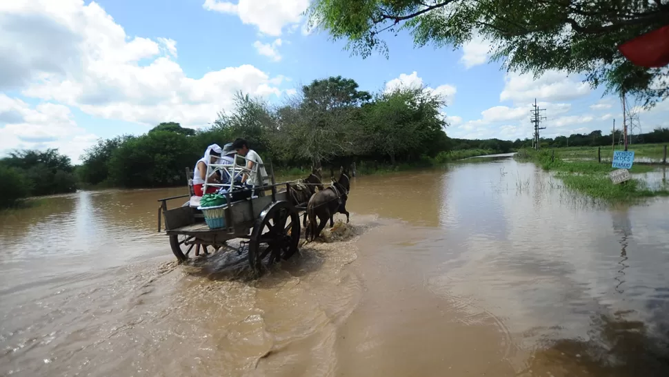 RUTAS Y CALLES ANEGADAS. Una familia se traslada a bordo de un carro en localidad de Niogasta, que quedó bajo el agua. LA GACETA / FOTO DE OSVALDO RIPOLL