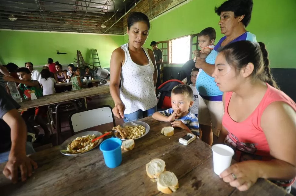 EVACUADOS. Mujeres y niños afectados por las inundaciones se alimentan en la escuela 99, de Monteagudo. la gaceta / fotos de osvaldo ripoll