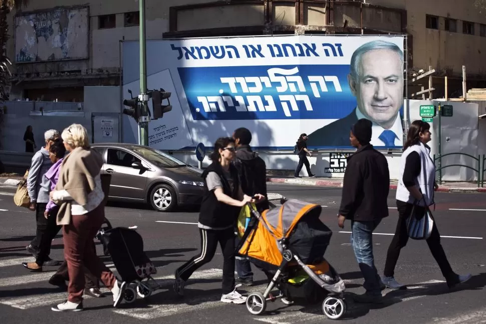 LA CAMPAÑA. En Ramat Gan, cerca de Tel Aviv, los pobladores pasean en medio de un enorme afiche que impulsa la candidatura de Netanyahu.   reuters