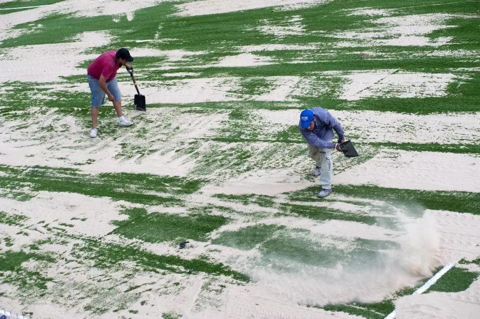 LISTA Los trabajadores colocan la arena sobre la carpeta sintética que ya está lista para que los planteles se entrenen. la gaceta / foto de diego aráoz