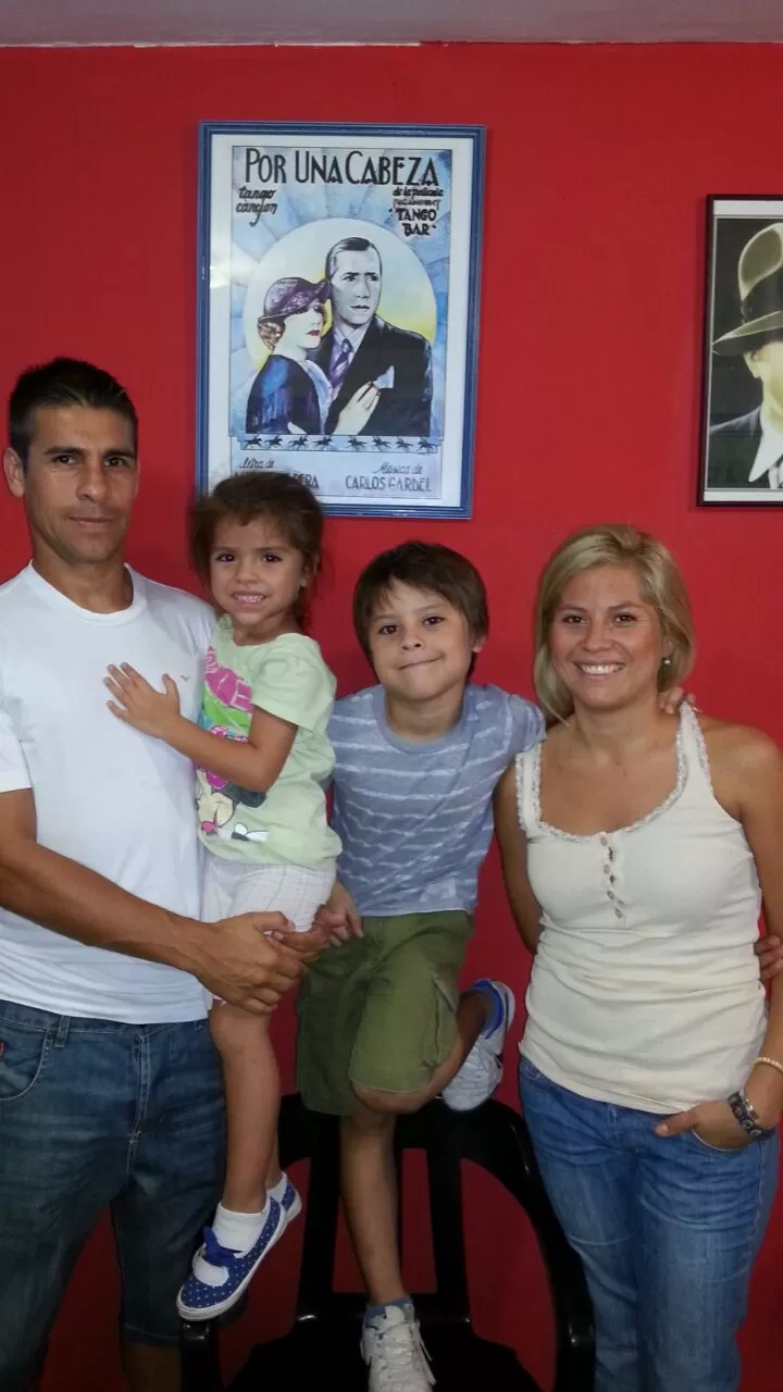 “POR UNA CABEZA”. “Lucho”, su familia y un cuadro de Gardel que explica su gol.   