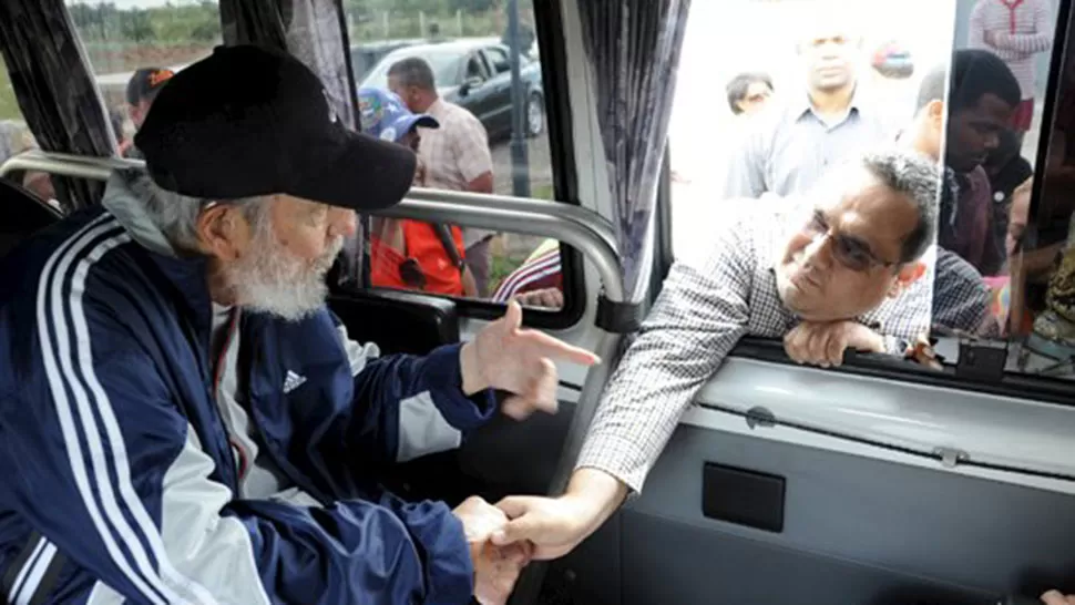 ADMIRADO. Castro saluda a un hombre desde adentro de un vehículo. REUTERS.