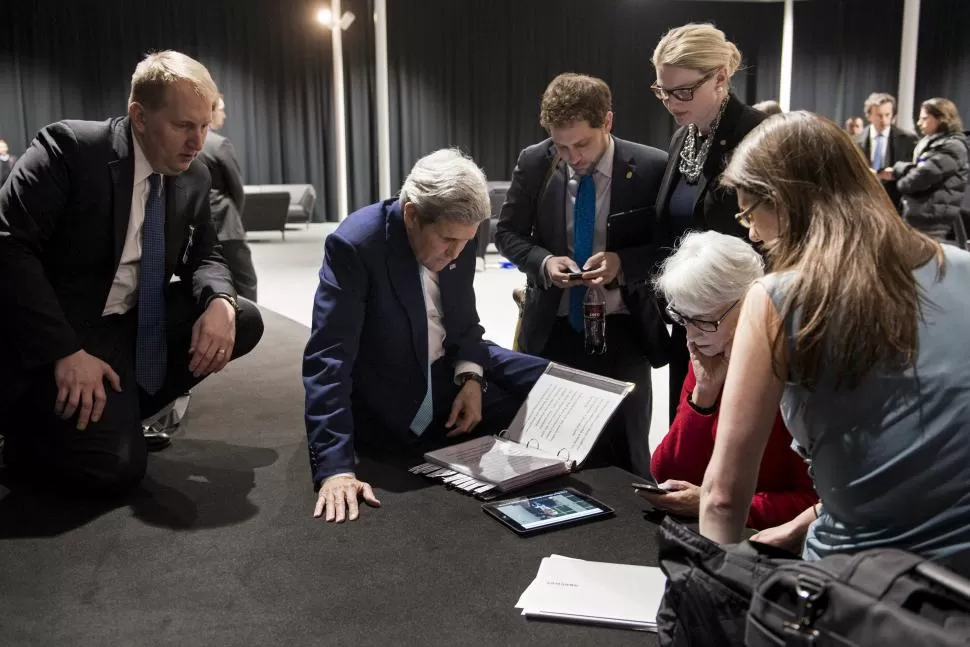 EN LAUSANA. El secretario de Estado, John Kerry y diplomáticos estadounidenses observan a través de una tablet el discurso del presidente Obama. REUTERS