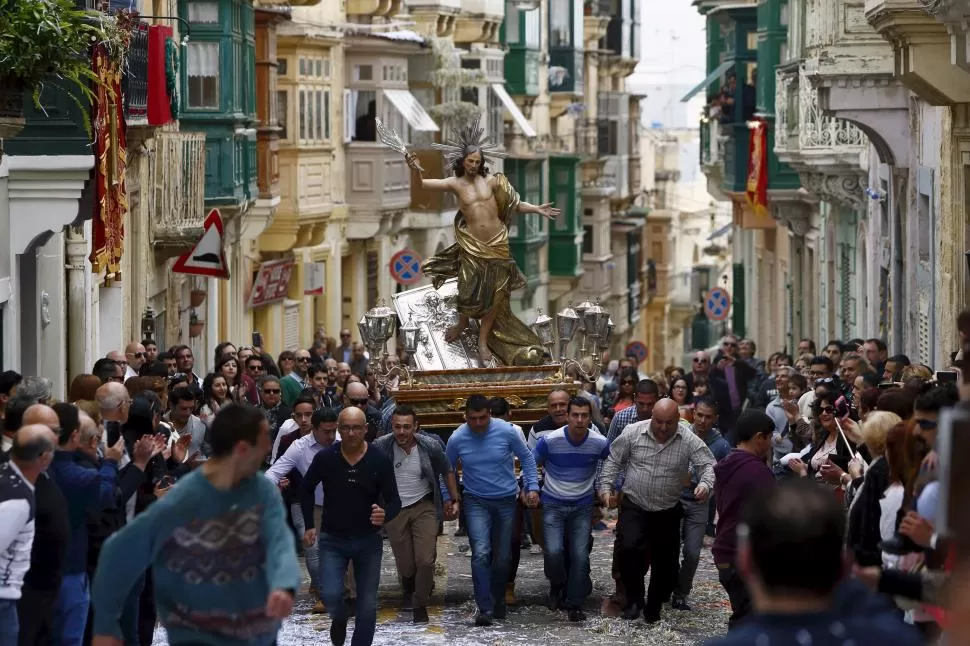 CARRERA DE FE. En Malta, los fieles corren con una imagen de Cristo a cuestas. fotos reuters