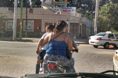 Llevan a una menor sentada en una pierna mientras viajan en moto