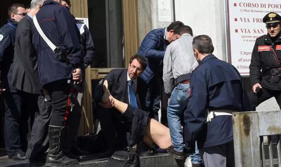 DESESPERACIÓN. Los rescatistas sacan a uno de los heridos en el Palacio de Justicia en la ciudad al norte de Italia. FOTO DE AGENCIA AP