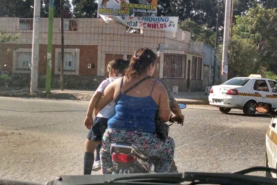 Llevan a una menor sentada en una pierna mientras viajan en moto