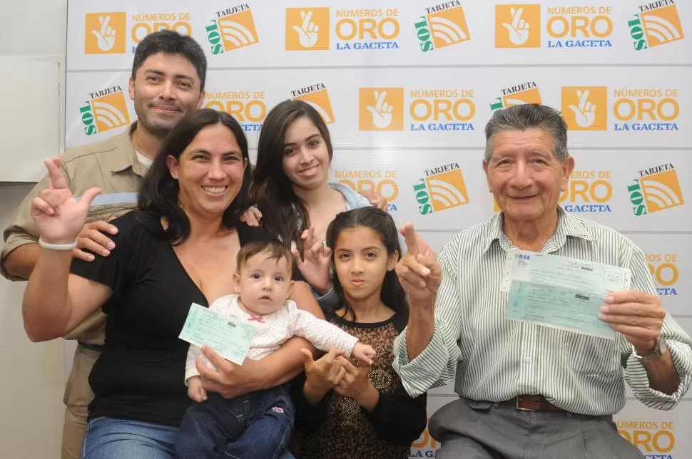 FELICES. Castro (rodeada por su familia) y López muestran los cheques. la gaceta / fotos de antonio ferroni