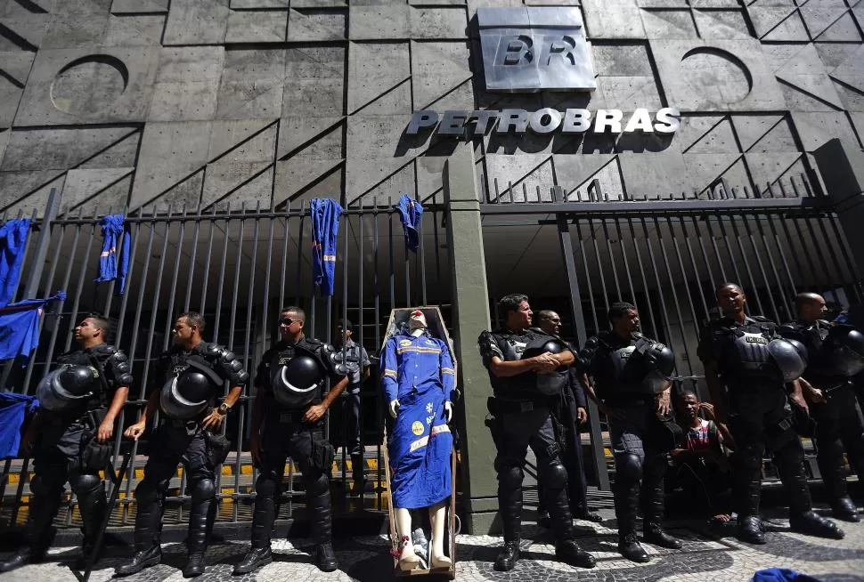 EN EL OJO DE LA TORMENTA. Policías antidisturbios custodian la sede central de Petrobras, luego de que la compañía anunciara despidos.  reuters