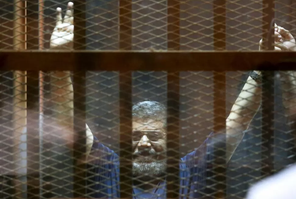 EN EL CAIRO. Detrás de una rejas, Mohamed Mursi escucha la sentencia. reuters