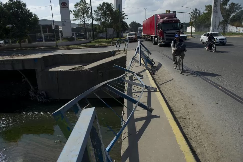 ALFREDO GUZMÁN Y AVENIDA ROCA. Los peatones no tienen más alternativa que circular por la calle, ya que el agua arrasó las barandas. la gaceta / foto de jorge olmos sgrosso 