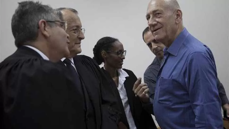 ACUSADO. El ex primer ministro israelí Ehud Olmert (derecha) conversa con sus abogados esta mañana en los juzgados en Jerusalén. FOTO TOMADA DE CLARIN.COM