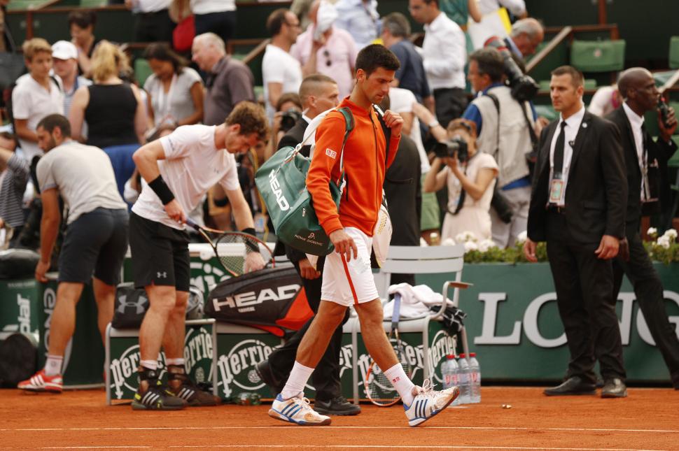 FIN. Djokovic se va de la cancha, mientras Murray termina de guardar sus cosas. REUTERS