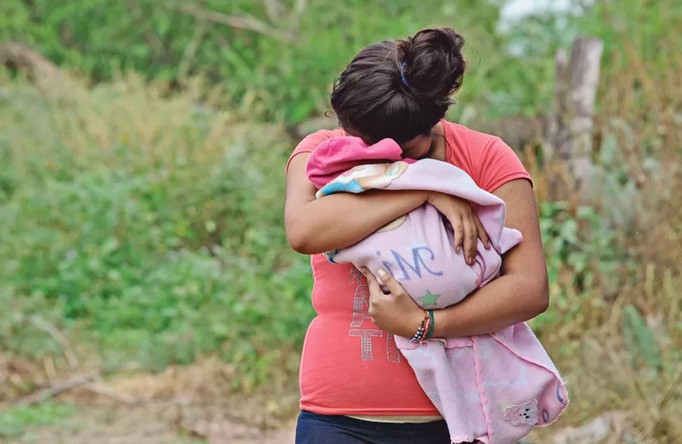 ​NIÑA MADRE. La víctima del abuso, que tiene 10 años, abraza a su bebé.