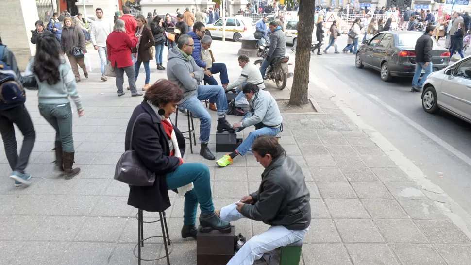 SACAR LUSTRE. Los hermanos Palavecino dan brillo a los zapatos en la zona bancaria. FOTO DE FRANCO VERA