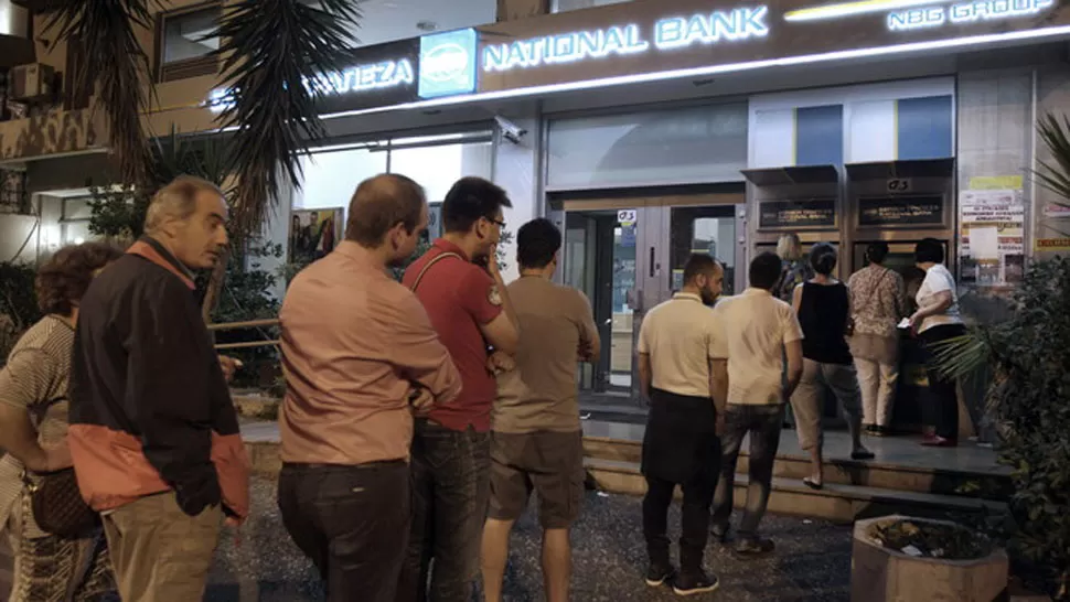 TEMORES. Ciudadanos griegos hacen cola ante el cajero del Banco Nacional de Grecia, en Atenas, esta madrugada. FOTO TOMADA DE ELPERIODICO.COM
