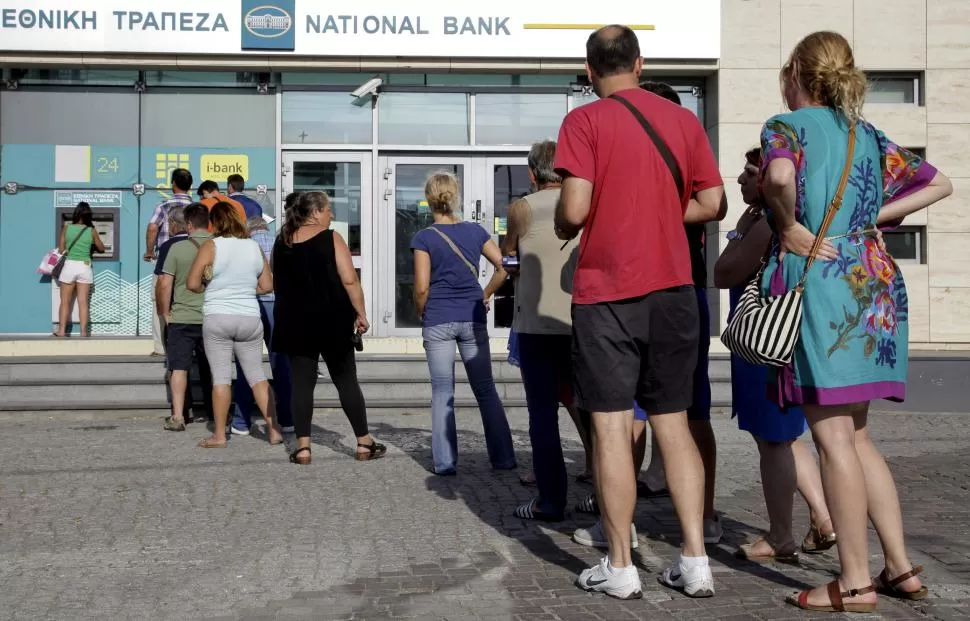 FILAS EN LOS CAJEROS. El Consejo de Estabilidad Financiera de Grecia recomendó limitar las extracciones en los cajeros automáticos a 60 euros diarios. reuters