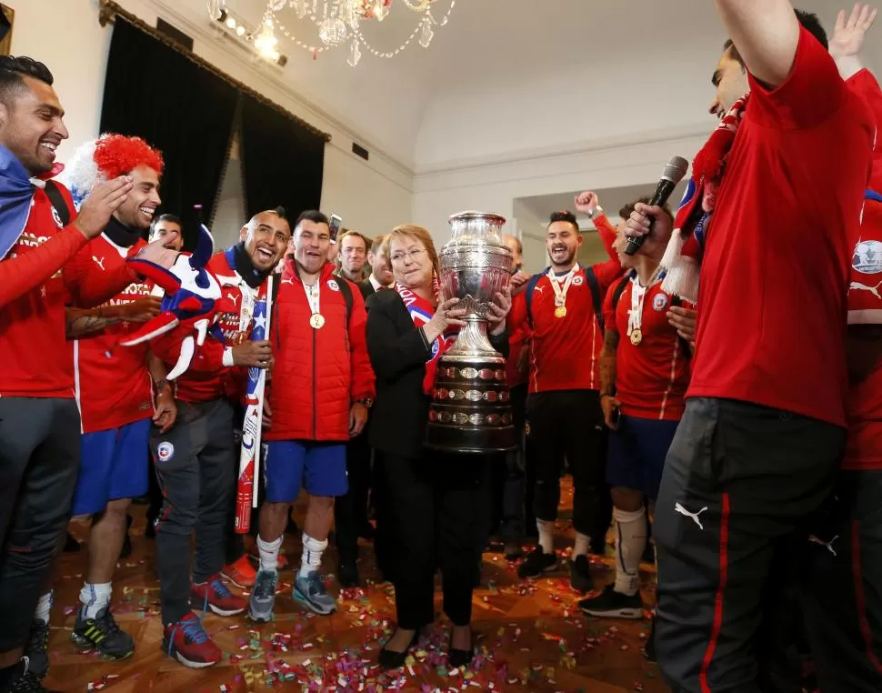 BUSCANDO POPULARIDAD. Bachelet recibió a los futbolistas que ganaron el sábado la Copa América. reuters