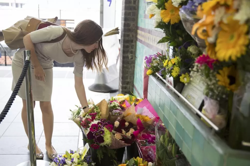 OFRENDA. Una ciudadana, familiar de una de una de las víctimas de los atentados en el metrobús de Aldgate East, deposita un ramo de flores. reuters