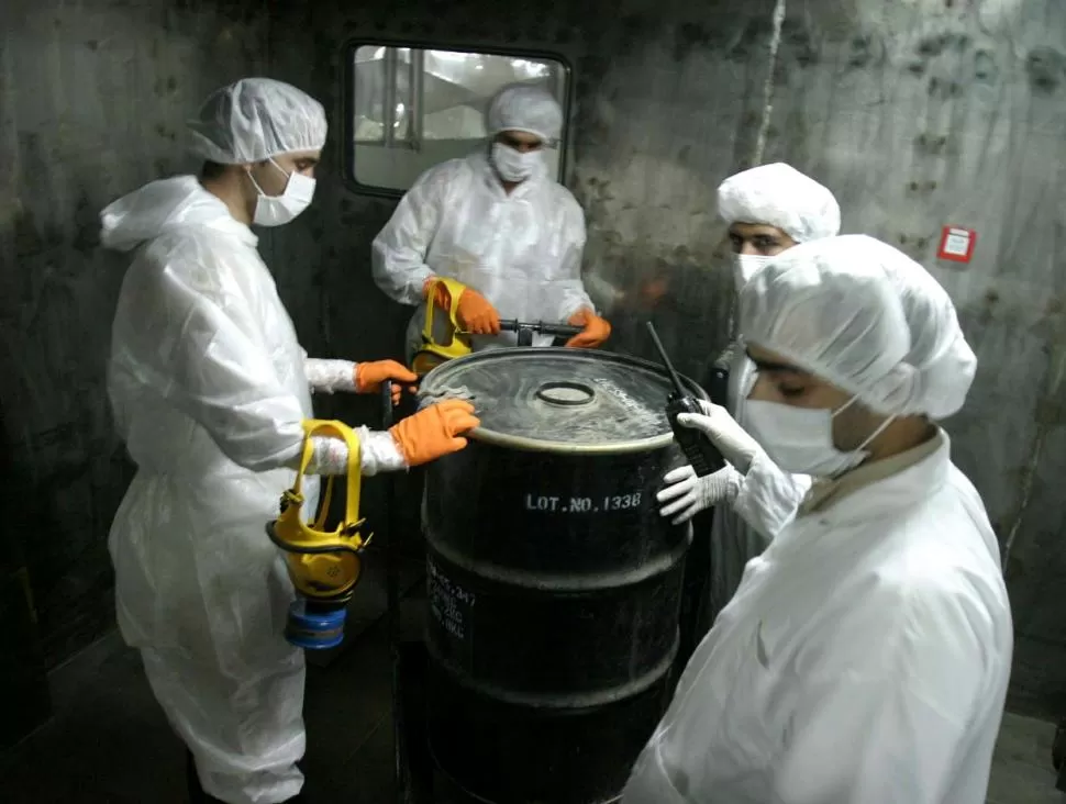 ARCHIVO. Técnicos iranies manipulan un barril de procesamiento de uranio. reuters