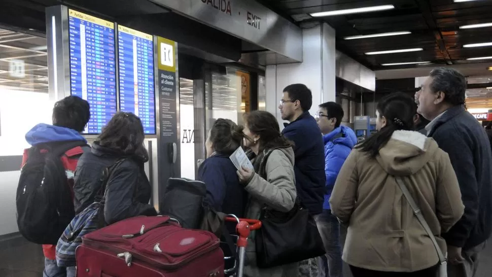 HORAS DE DESCONCIERTO. Cientos de pasajeros se apostaron sobre los tableros de información para conocer el estado de su vuelo. ARCHIVO