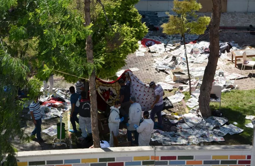 DESTROZOS Y MUERTE. Policías inspeccionan el lugar del ataque en Suruc. reuters