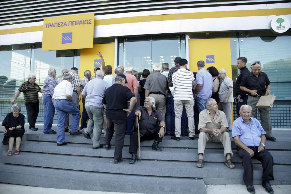AFLUENCIA. Miles de griegos se concentraron ayer frente a las entidades bancarias, para poder retirar hasta un máximo de 420 euros por semana. reuters