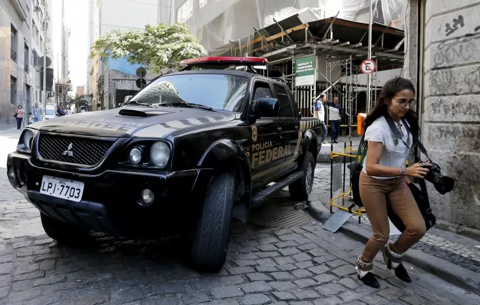 EN RÍO DE JANEIRO. Un vehículo de la Policía Federal de Brasil se retira de la sede de la empresa Electronuclear, durante un operativo de requisa. reuters
