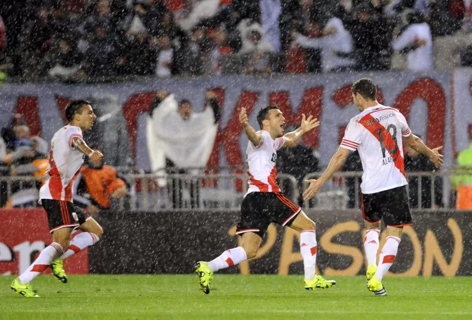 GRITO SAGRADO. Alario ya convirtió el gol y lo festeja con Bertolo y Vangioni. El título esta vez llegó bajo una intensa lluvia. TÉLAM