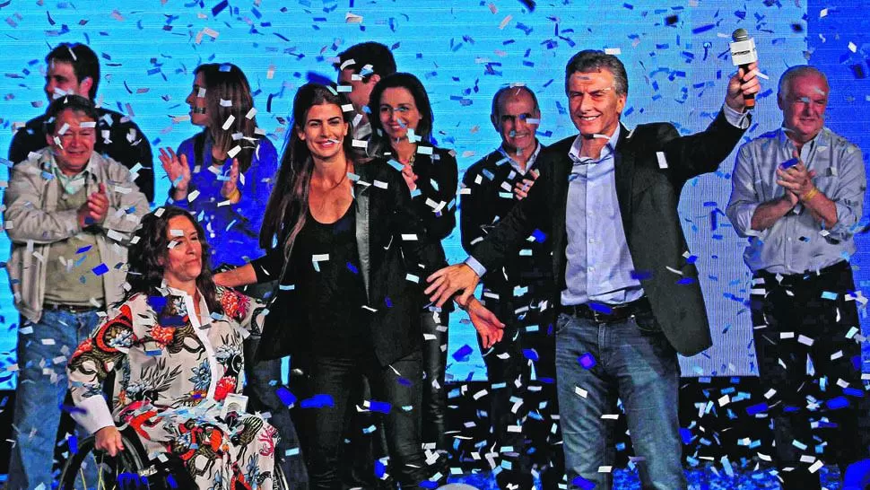 CELEBRACIÓN. Junto a su compañera de fórmula, Gabriela Michetti, y a su esposa, Juliana Awada, Macri festeja en medio de una lluvia de papelitos.
