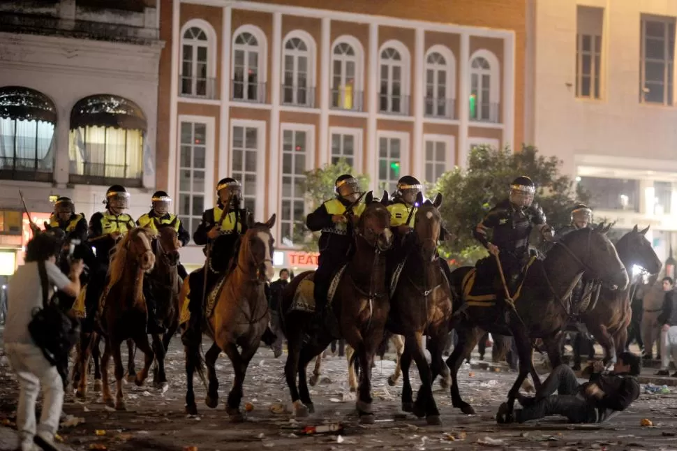 CAOS Y TERROR. Policías a caballo fueron convocados para reprimir a manifestantes frente a Casa de Gobierno. En la imagen uno de los uniformados está próximo a descargar un latigazo contra un hombre que está en el suelo. la gaceta / foto de diego aráoz