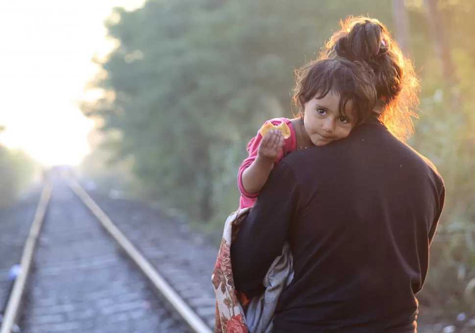 DESDE SERBIA. La mamá lleva a su hijito, siguiendo las vías del ferrocarril. reuters