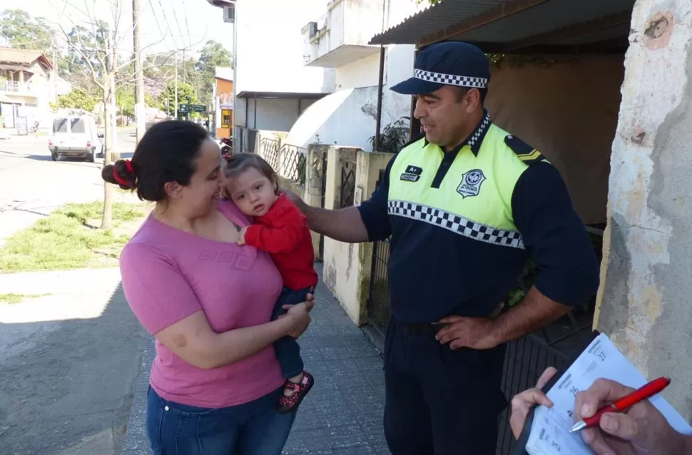 DESPUÉS DEL SUSTO. La pequeña Liz, cargada en los brazos de su mamá, es acariciada por el cabo que la salvó de morir ahogada. la gaceta / foto de osvaldo ripoll