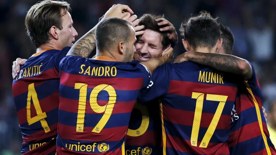 FELICES. Messi recibe el abrazo de sus compañeros al anotar su primer gol. (REUTERS)