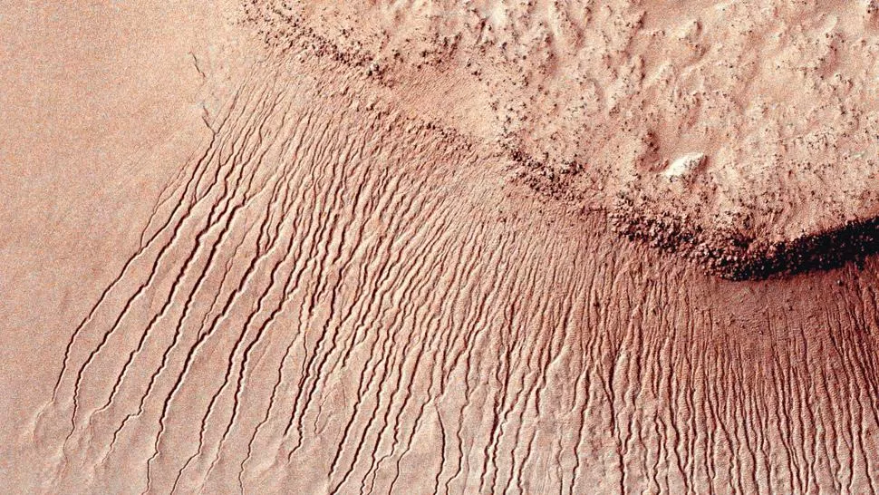 PRUEBA CONTUNDENTE. Una de las fotos difundidas ayer por la NASA en la que pueden verse las líneas de agua corriendo por el suelo marciano. Reuters.