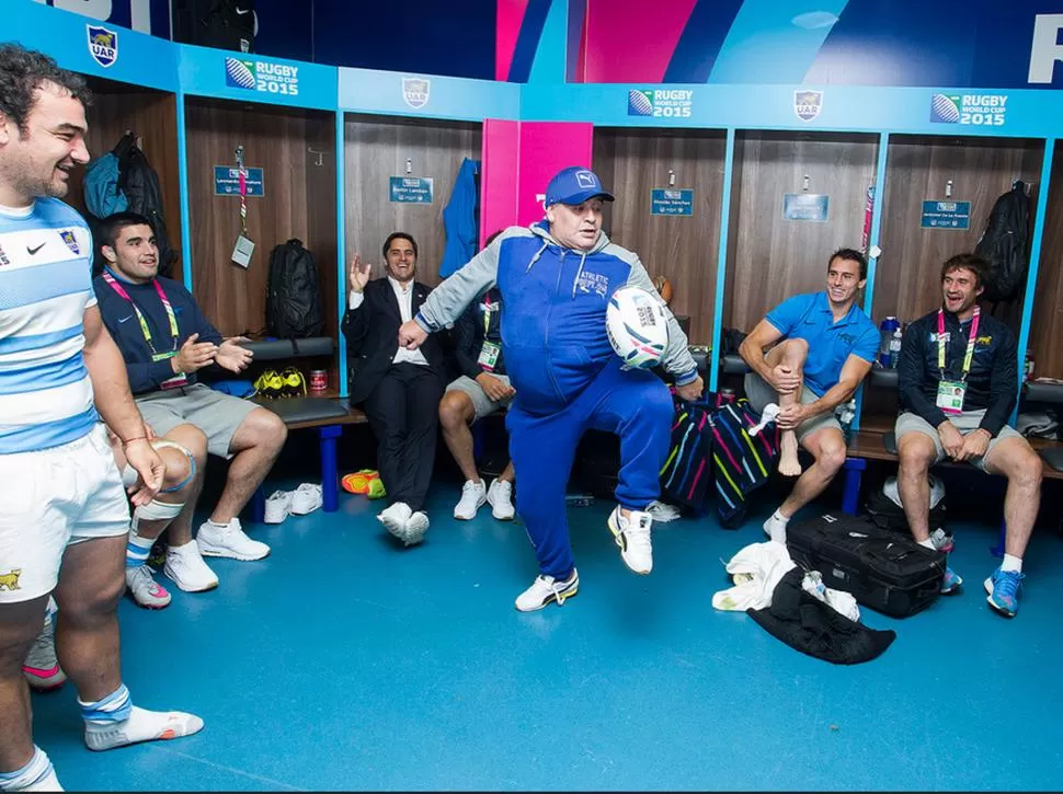 CON LA OVALADA TAMBIÉN. Maradona intenta (exitosamente) hacer jueguitos con la pelota de rugby ante la mirada y el asombro de Creevy, Pichot e Imhoff, entre otros miembros del plantel Puma.  PRENSA UAR