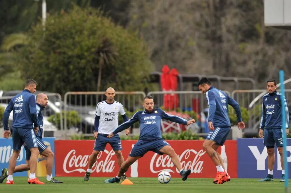 LA PRIMERA PRÁCTICA EN EZEIZA. Nicolás Otamendi y Ezequiel Garay disputan la pelota, ante la mirada de Javier Mascherano y de Ramiro Funes Mori. télam