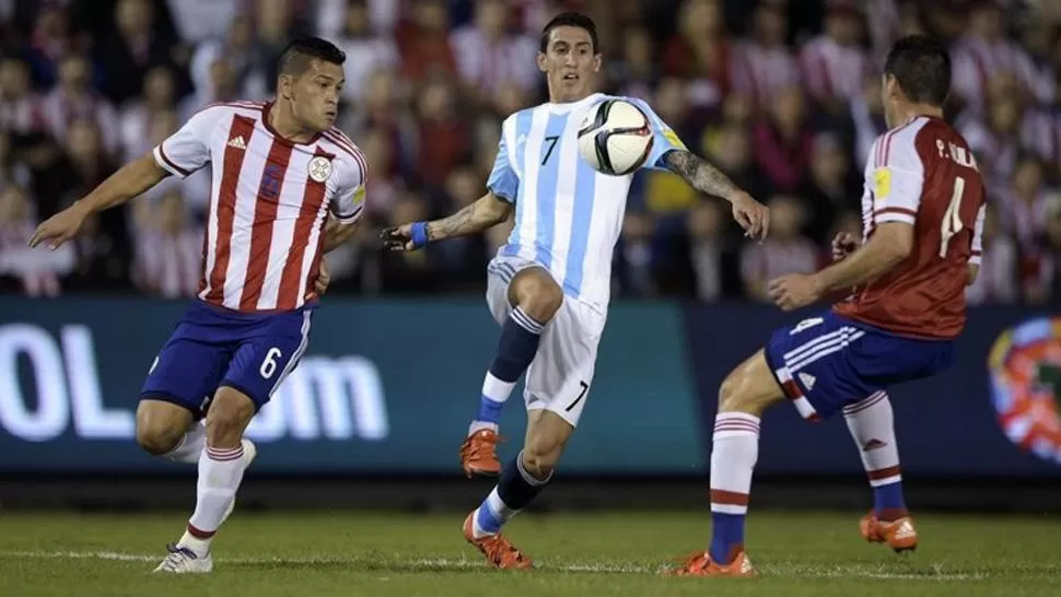 CON TODO. Di María busca la bocha entre la doble marca de Paraguay. (INFOBAE)