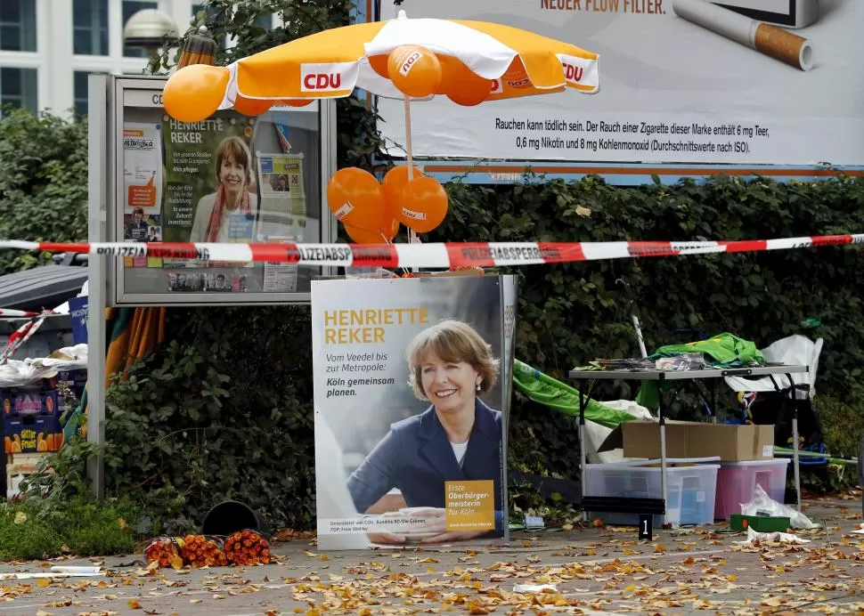 EN COLONIA. Vecinos depositaron flores ante un afiche de la candidata apuñalada, Henriette Reker. reuters