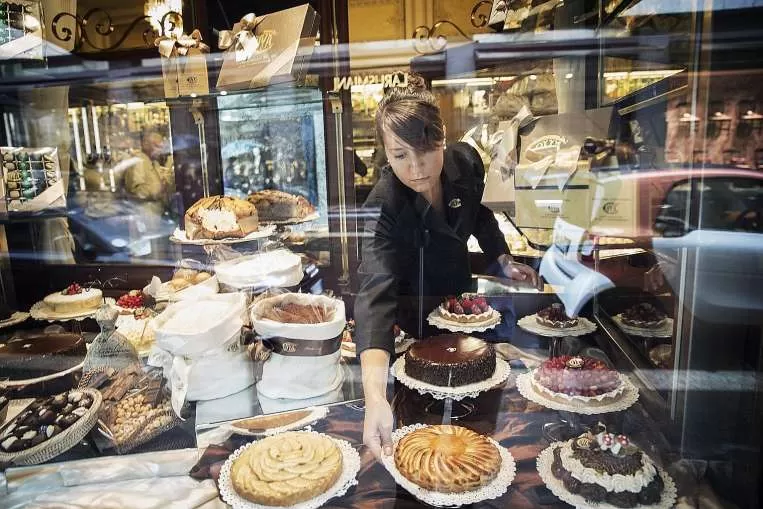 DELICIAS DE LUJO. Una empleada acomoda algunas tentadoras tartas y pasteles en la vidriera de Cova Café, de Louis Vuitton. The New York Times