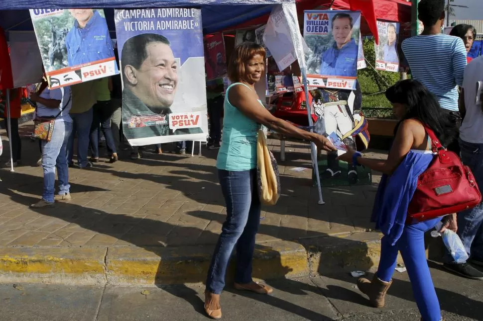 BUSCANDO VOTOS. Los militantes chavistas reparten panfletos en las calles. reuters