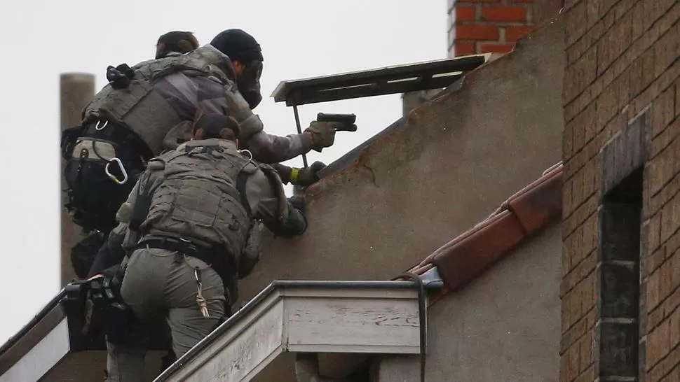 OPERATIVOS. Las fuerzas belgas ingresan armados y con máscaras a una vivienda. REUTERS