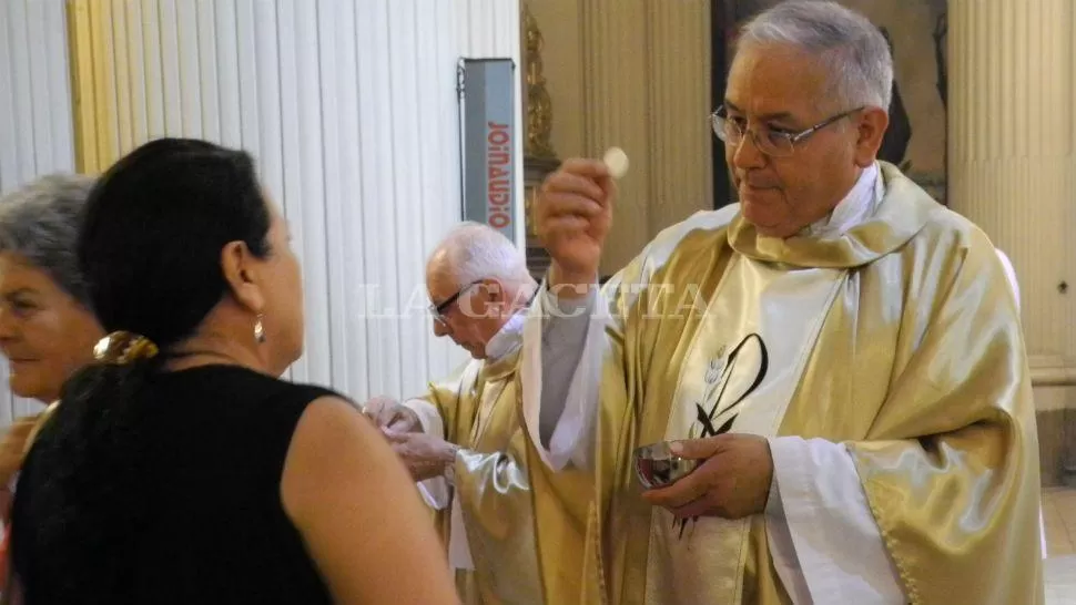 EN LA CATEDRAL. El padre Melitón le da la comunión a una mujer durante la misa que celebró el jueves en la Catedral. JOSÉ NUNO / LA GACETA