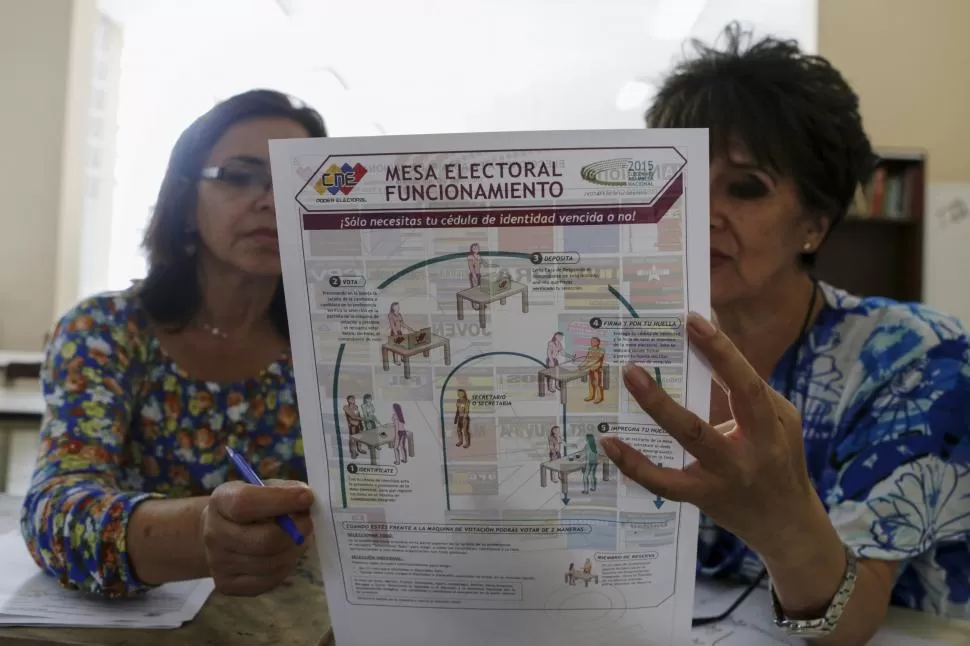 CARACAS. Trabajadores de la Comisión Nacional Electoral leen un folleto que explica el proceso de votación.  