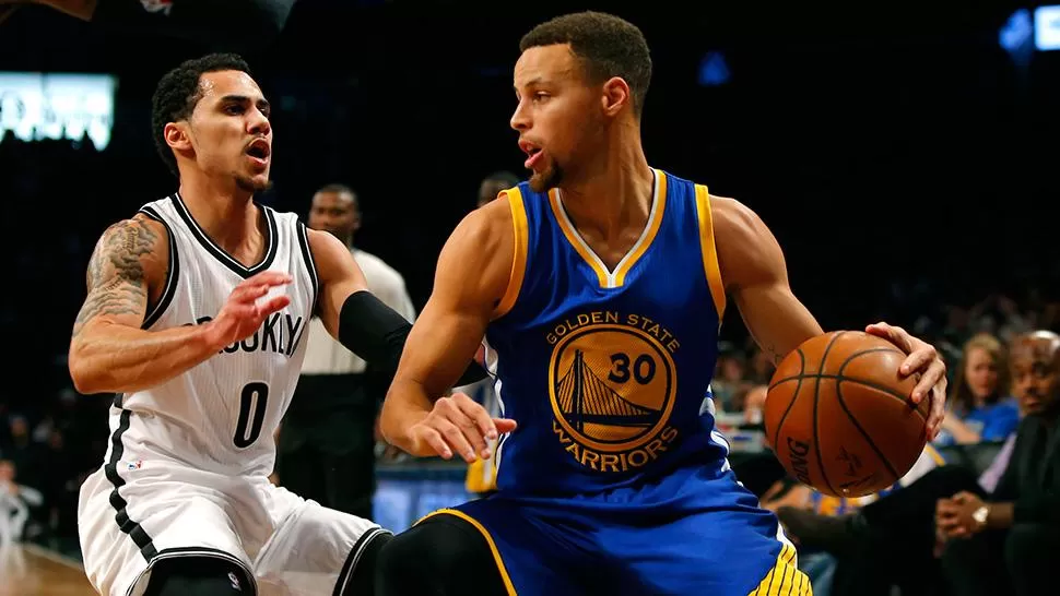 EN LLAMAS. Stephen Curry promedia 32.4 (47% de aciertos en triples), 4.9 rebotes y 5.8 asistencias, Dafiende Shane Larkins, de los Nets.
FOTO DE REUTERS
