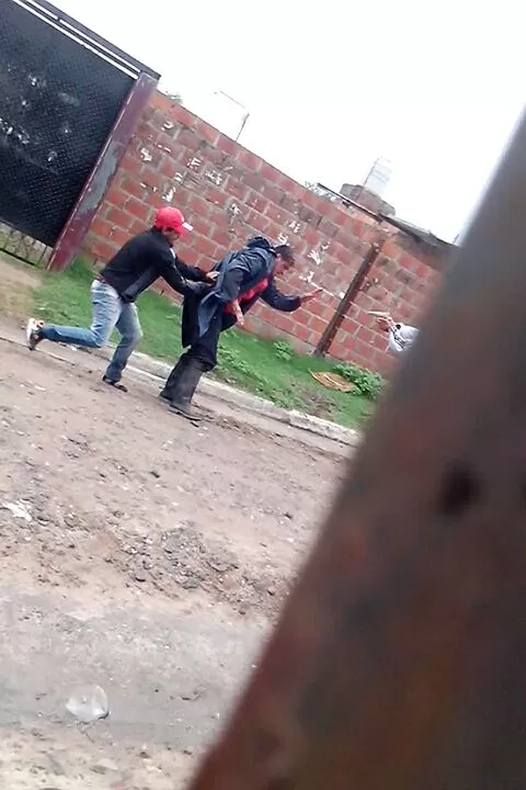UNA PRUEBA. Un delincuente le quita el arma al policía mientras el otro -tapado con la pared- le apunta. captura de video