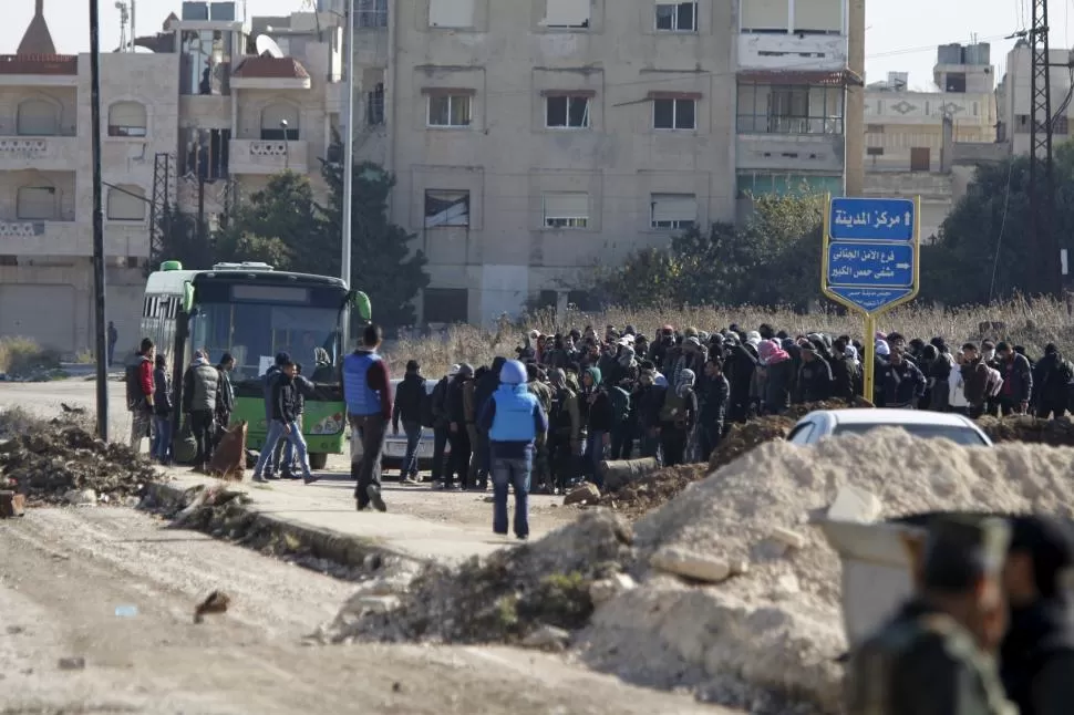 TREGUA. Ómnibus llenos de sirios abandonaron la última área en poder de los insurgentes en Homs (Siria). reuters